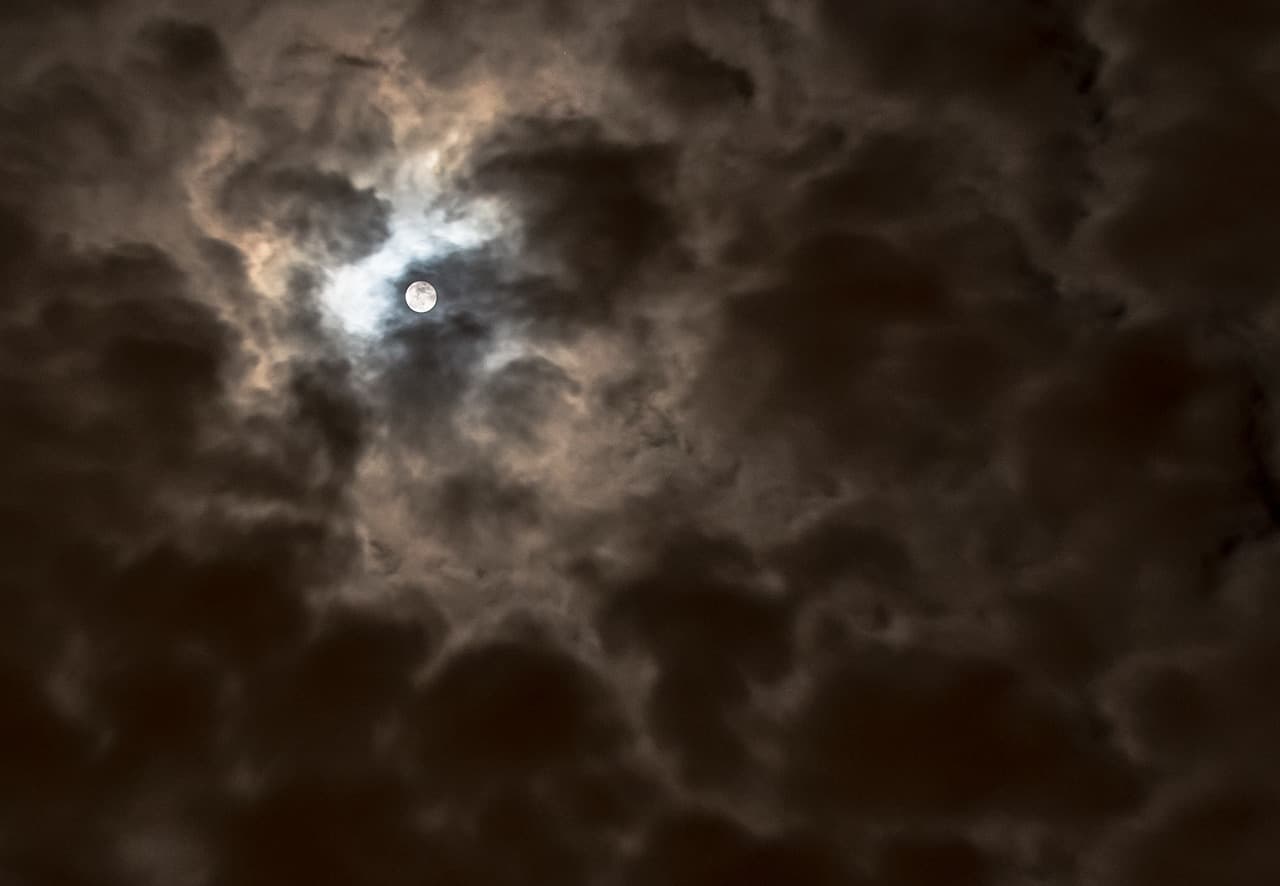 the moon through clouds night landscape photography