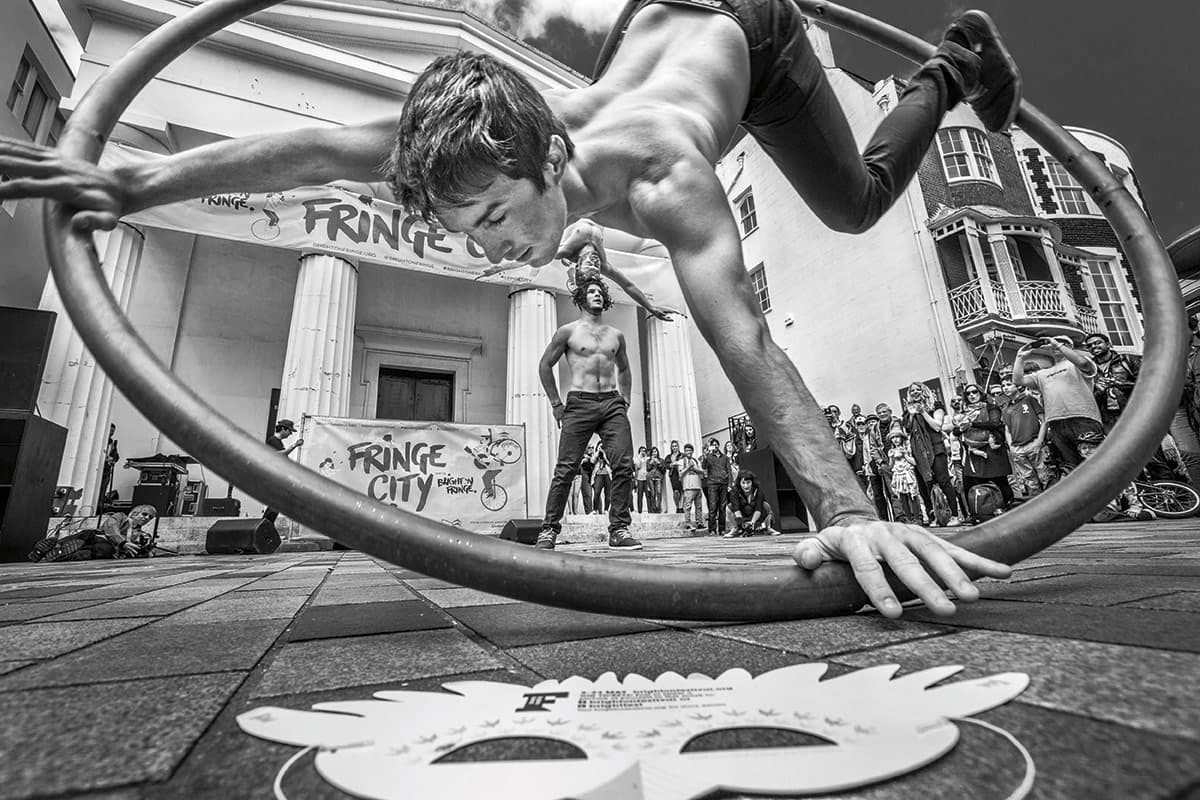 Ultra low angle shot of street acrobats performing in front of a crowd