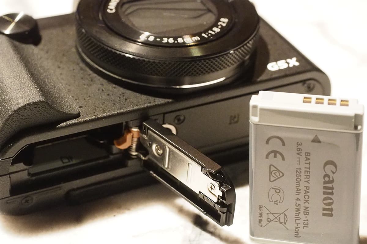 The NB-13L sits next to the SD card and is good for 210 shots per charge, or 215 using the EVF
