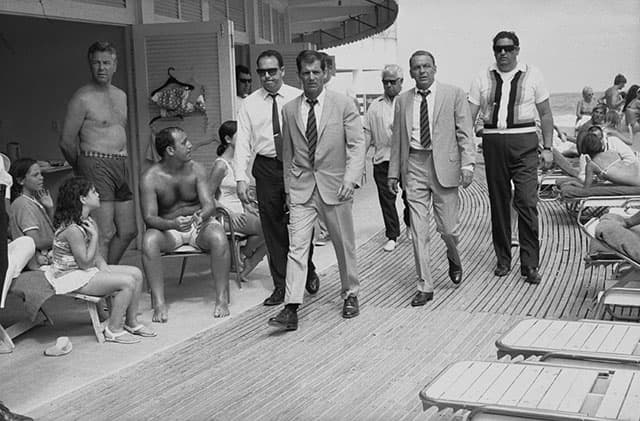 Singer and actor Frank Sinatra, with his minders and his stand in (who is wearing an identical outfirt to him), arriving at Miami beach while filming, 'The Lady In Cement', 1968. (Photo by Terry O'Neill/Getty Images)