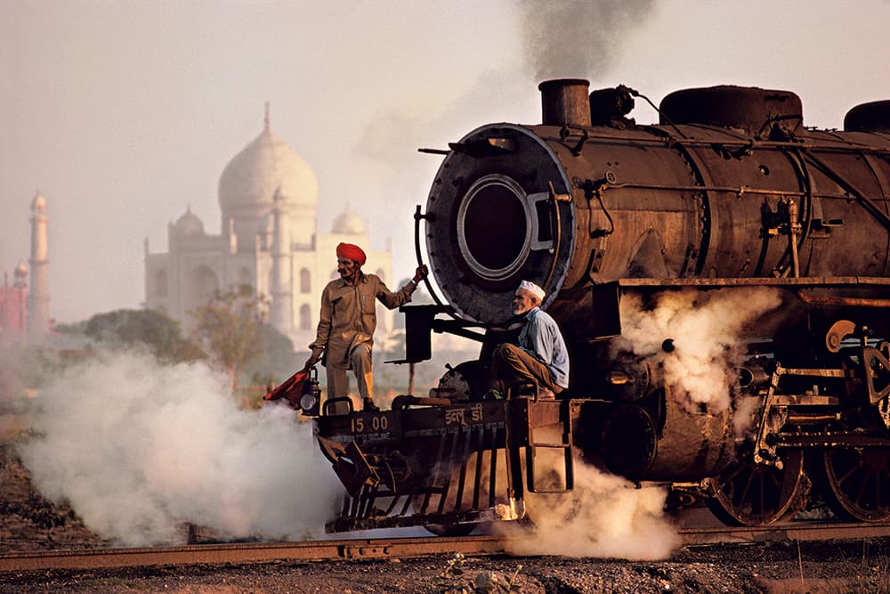 Steve McCurry Agra 1983. A steam train passes in front of Taj Mahal