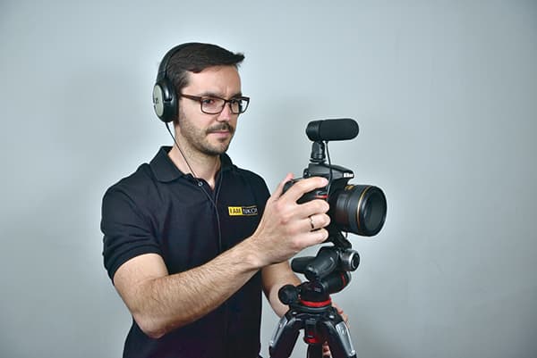 A man wearing headphones in uniform taking a picture using a tripod