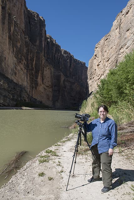 Photographer Carol M. Highsmith pauses between clicks of her Phase One 80-megapixel professional camera at the Santa Elena Canyon, deep in Big Bend National Park in Brewster County, Texas. A sheer rock wall in Mexico is to the left; one in the United States to the right.