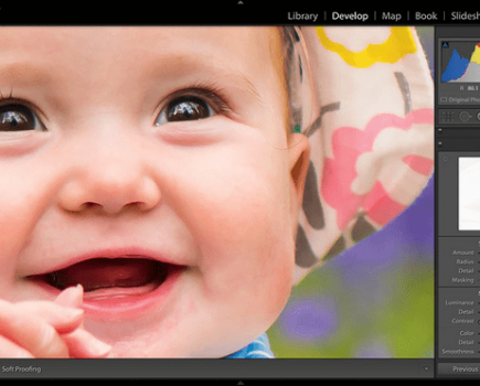 Close up of a brown eyed baby smiling in the Lightroom software