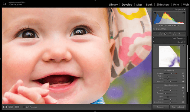 Close up of a brown eyed baby smiling in the Lightroom software