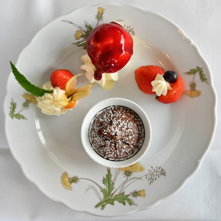 Nikon D7500 sample image, food photography, a small pot of dessert on a white plate garnished with strawberries and cream