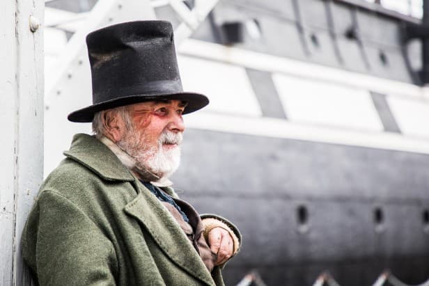 Canon EF 24-105mm f/4L IS II USM sample image, portrait of an old man in a green coat and top hat, a ships side in the background