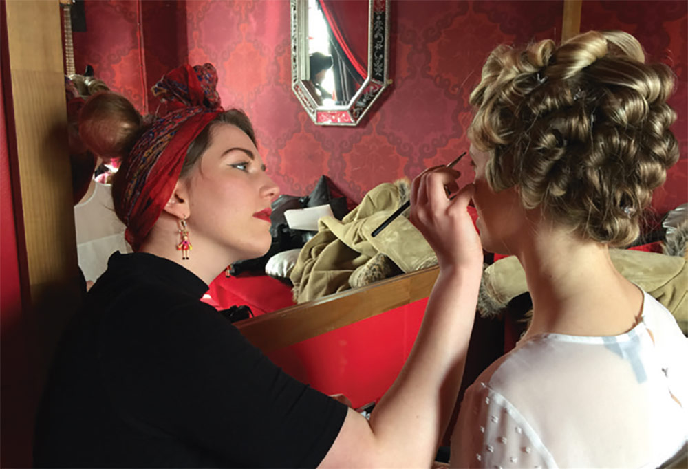 Boudoir Photography: Hair and make-up: Stacie Smith applying make-up to the model in an all red room