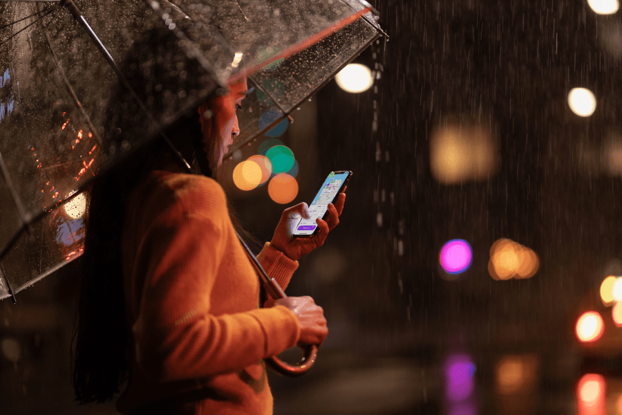 Girl in yellow jumper under a clear umbrella in the dark on iphone