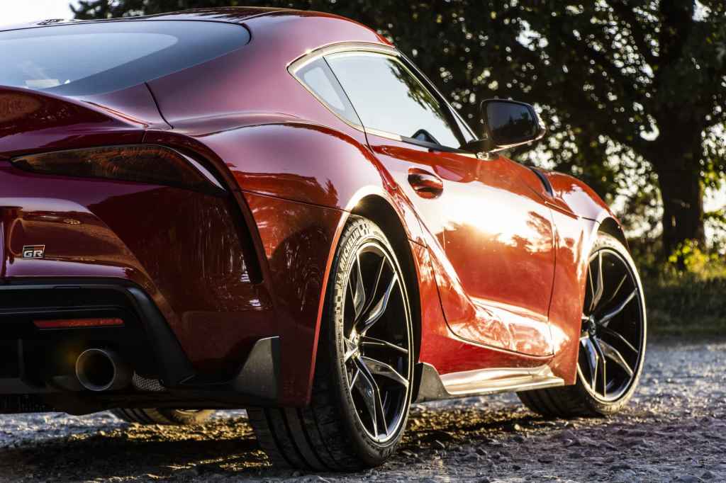 Sample image, red sportscarphotographed from a low angle, the setting sun is reflected on the car's paintwork