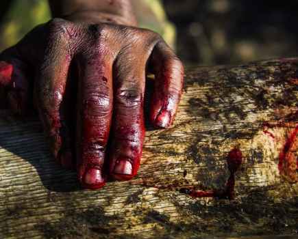 A ranger’s bloody hand rests on an ivory tusk during an anti-poaching mission in KwaZulu-Natal, South Africa © Britta Jaschinski / Photographers Against Wildlife Crime™