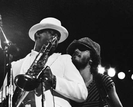 Black and white capture of muscians on stage, one holds a trumpet