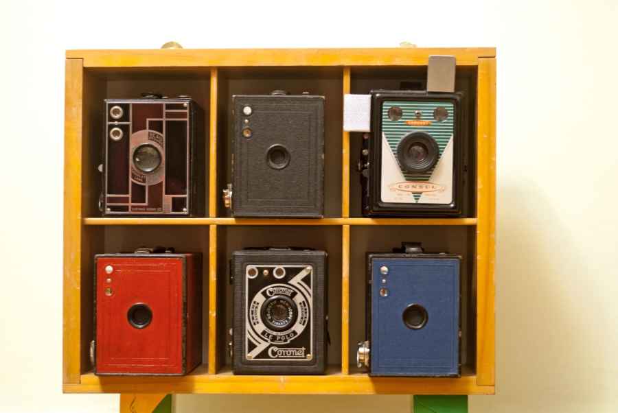 Six part yellow storage unit holding six Ensign cameras