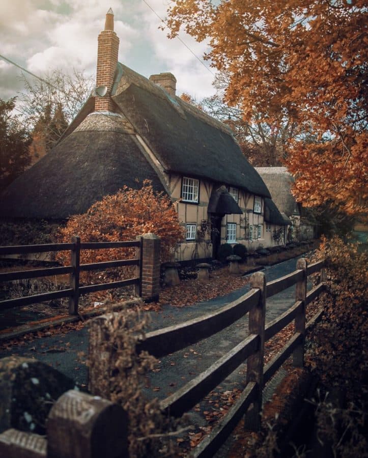autumn landscape with thatched cottage in background