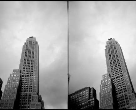 grey scale double image of a new york skyscraper from below
