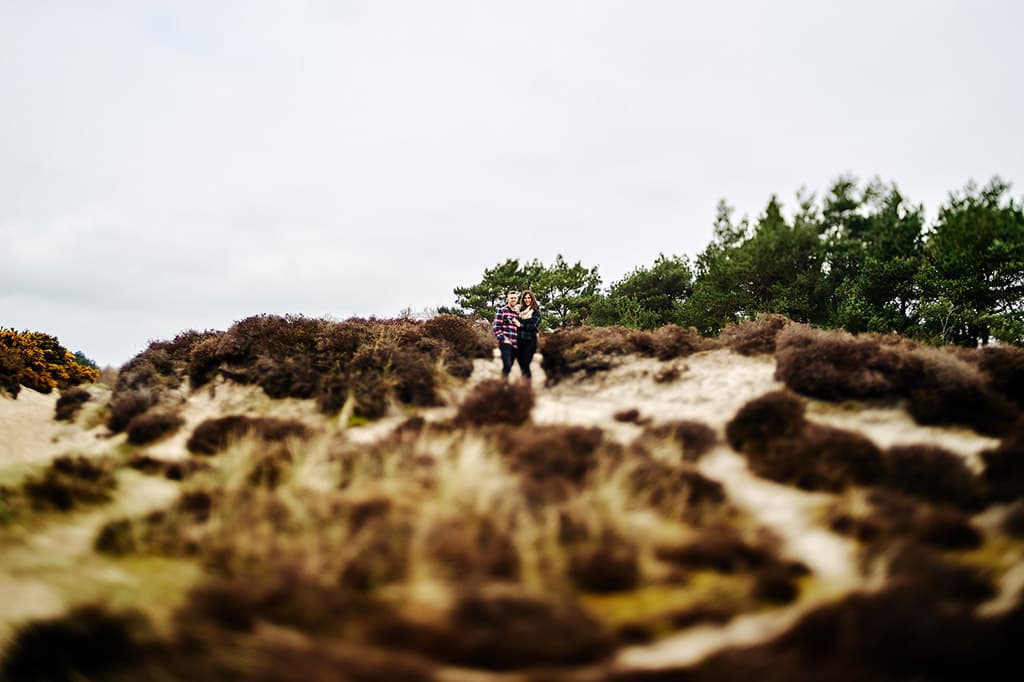 Distance shot of a just-engaged couple on the beach manual focus