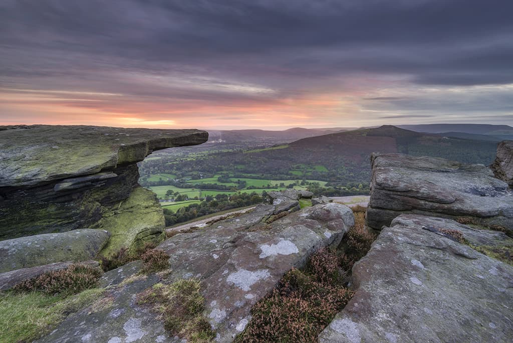 long-exposure sunset with clouds and rocks in the foreground