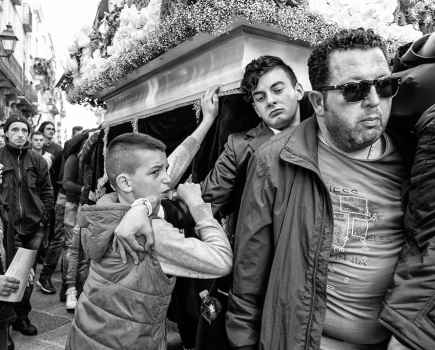 Black and white capture of men carrying coffin in Sicilie