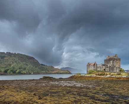 Coastal landscape with an old castle next to the water