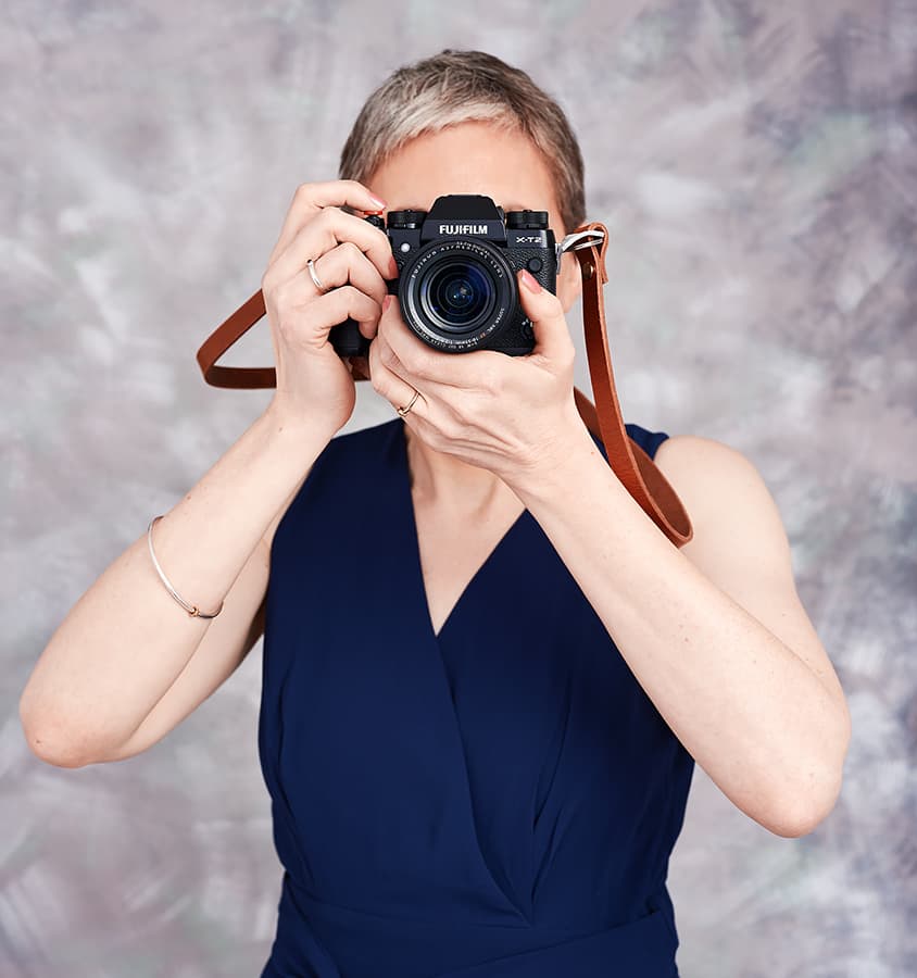 Woman holding up a Fujifilm camera to her face