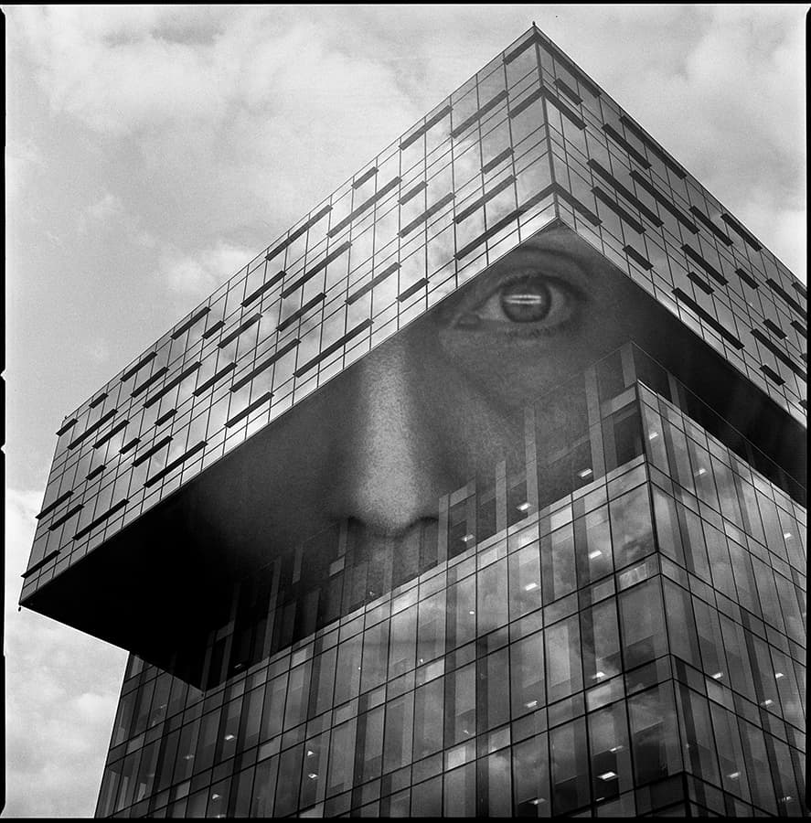 black and white double exposure face on a building