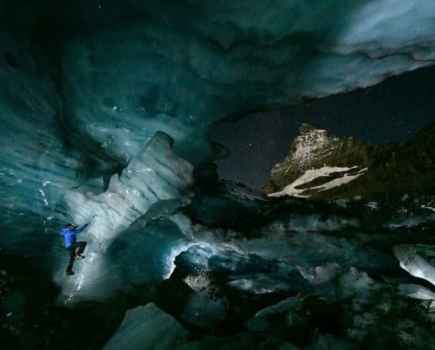 A man in a blue jacket climbing a glacier for a National Geographic shoot