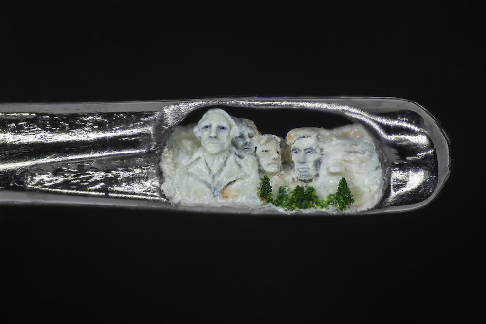 A close-up, shot on the OPPO Find X3 Pro smartphone, of a microscopic sculpture of the famous Mount Rushmore monument by Dr. Willard Wigan MBE