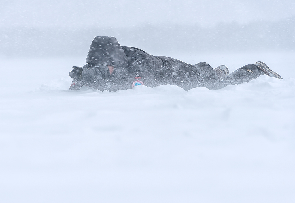 Marsel van Oosten lying down in a blizzard to shoot in Hokkaido, Japan bad weather