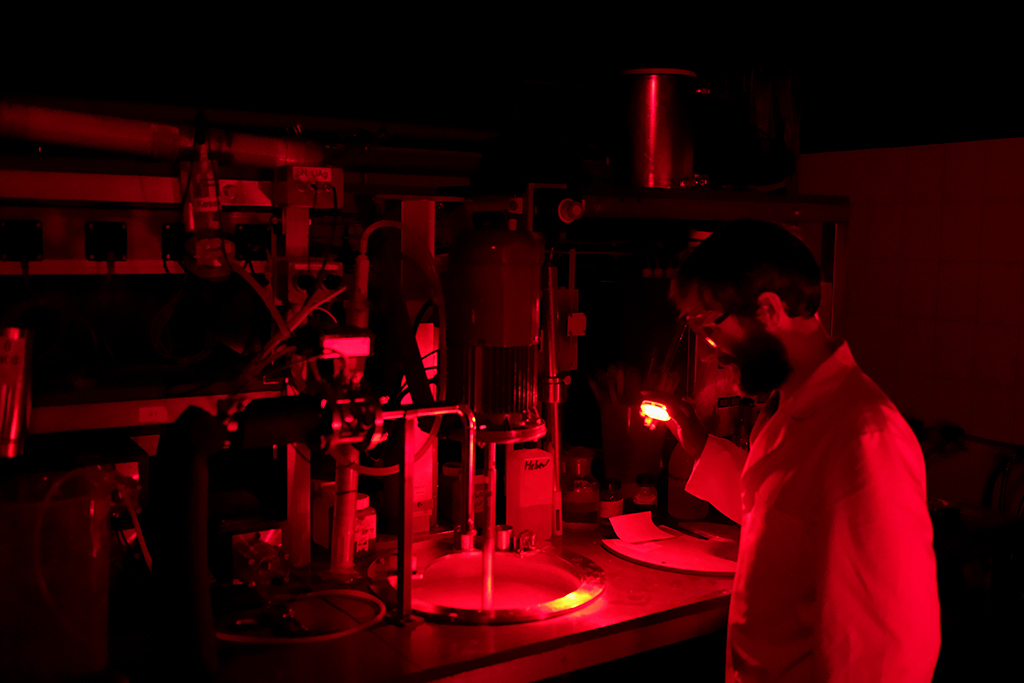 Adox engineer working under red light on the firm’s Precipitation Machine, 