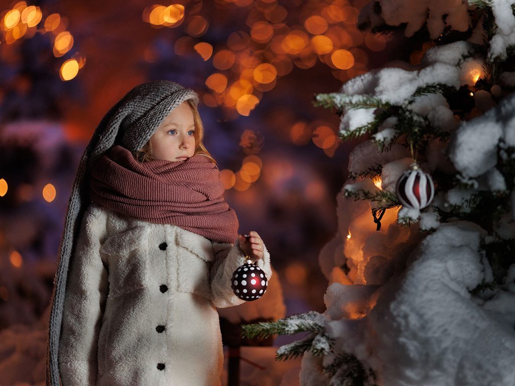 girl looking at snowy christmas tree on photography holiday