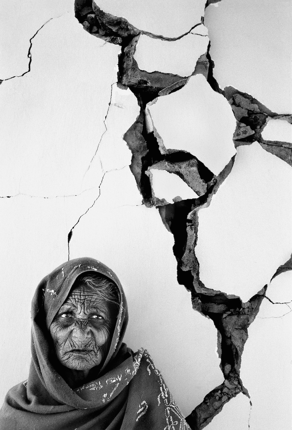 Anjar, India, February 2001: with silent dignity an elderly woman waits for aid to arrive at her stricken village near Anjar, Gujarat, after the earthquake of 2001. The quake lasting 90 seconds killed 20,000 people in the north western state of Gujarat, left 200,000 injured and countless homeless. Photo: © Tom Stoddart