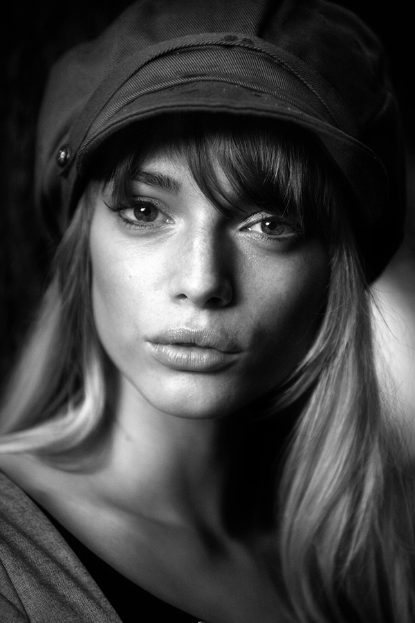 black and white close up portrait of a woman wearing a baker boy hat