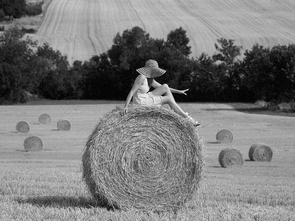 black and white portrait woman on a hay bale