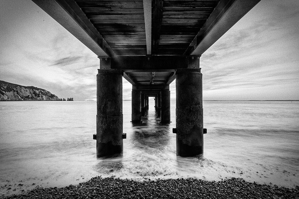 black and white under a pier image