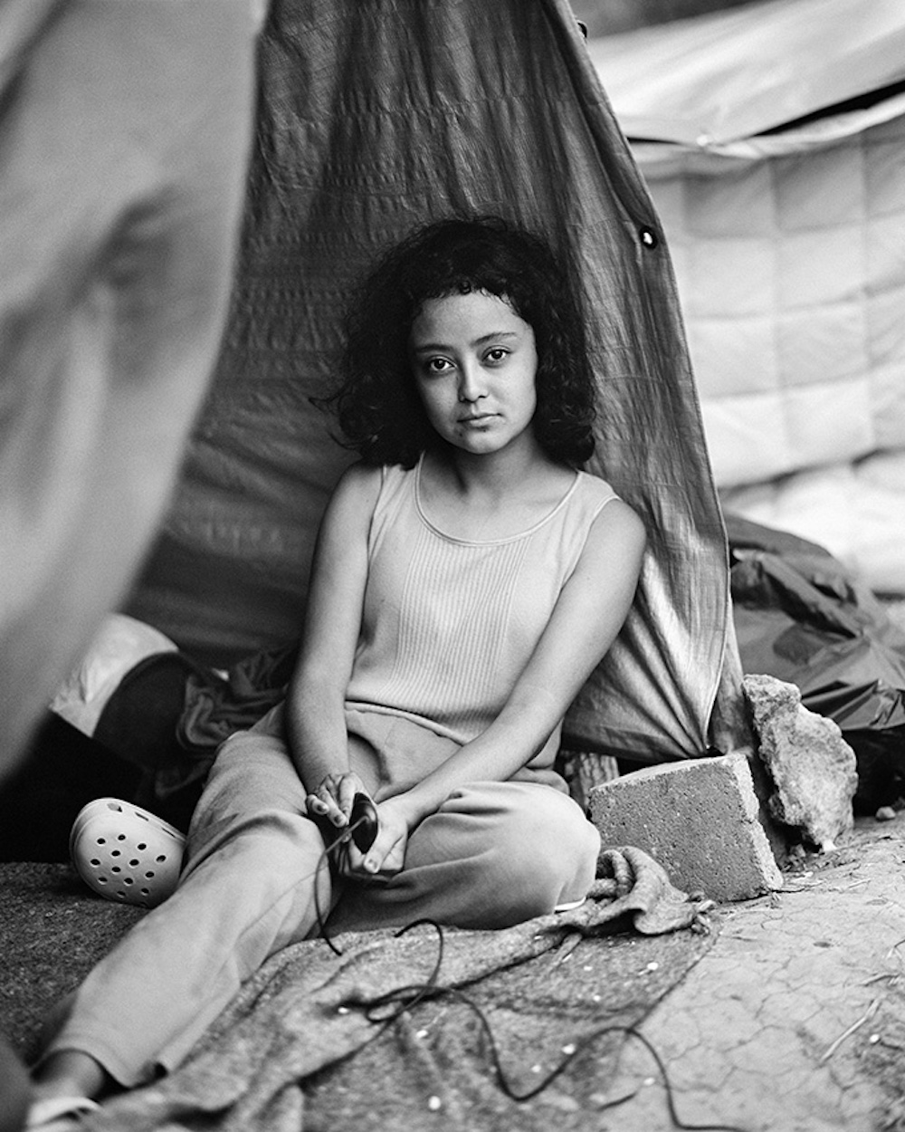 Stephanie Solano, age 17, from Zacapa, Guatemala. She takes a portrait of herself at an informal migrant camp at a municipal park in Reynosa, Tamaulipas, Mexico on 3 May 2021. Series Name: Migrantes. © Adam Ferguson, Australia, Photographer of the Year, Professional, Portraiture, 2022 Sony World Photography Awards
