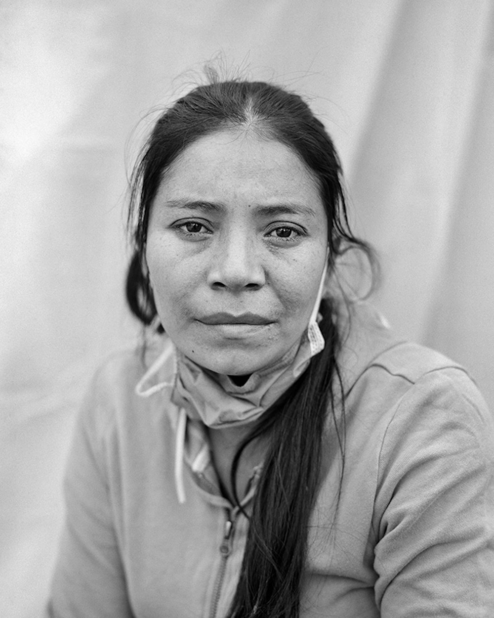 Doris Maria Lara Caballero, age 31, is a migrant from Department Cortés, Honduras. She takes a portrait of herself at the Enrique Romero Municipal Gymnasium in Juárez, Chihuahua, Mexico on 30 April 2021. Series Name: Migrantes. © Adam Ferguson, Australia, Photographer of the Year, Professional, Portraiture, 2022 Sony World Photography Awards exhibition