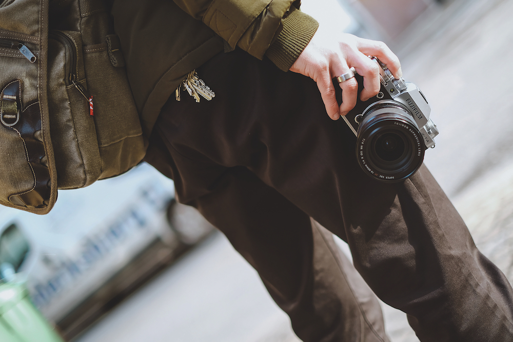 a person holding a Fujifilm camera