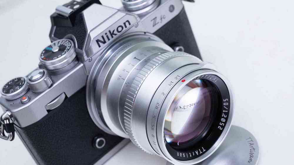 The silver TTArtisan 50mm f/1.2 mirrorless APS-C lens shown on a Nikon Z fc camera