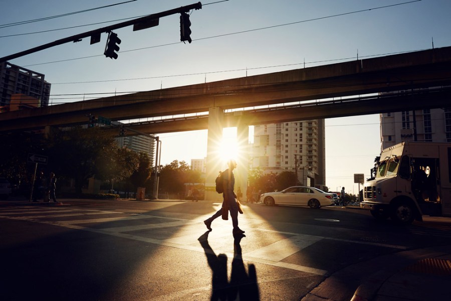 Man crossing road at sunset in Miami, Credit: Ezra Bailey, Getty Images