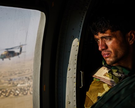 A soldier surveys the terrain out of the window of a UH-60 Black Hawk during a resupply flight toward an outpost in the Shah Wali Kot district north of Kandahar, Afghanistan, on 6 May 2021. The Afghan Air Force, which the US and its partners have nurtured to the tune of $8.5 billion since 2010, is now the government’s safeguard in its fight against the enemy. Since May 1, the original deadline for the U.S. withdrawal, the Taliban have overpowered government troops, wrestling away control of territories and further denying Afghan security forces the use of roads. As a result, all logistical support to thousands of outposts and checkpoints — including re-supplies of ammunition and food, medical evacuations or personnel rotation — must be done by air.⁣ © Marcus Yam