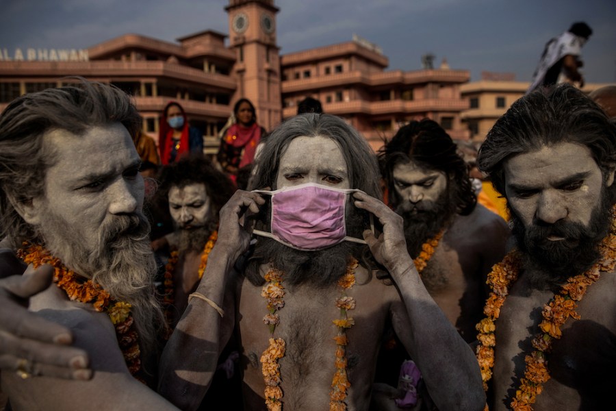 A ‘Naga Sadhu,’ or Hindu holy man, places a mask across his face before entering the Ganges river during the traditional Shahi Snan, or royal dip, at the Kumbh Mela festival in Haridwar, India, 12 April 2021. As COVID-19 cases and deaths exploded in India in April and May, hospitals ran so short of oxygen that many patients suffocated. © Danish Siddiqui/Reuters