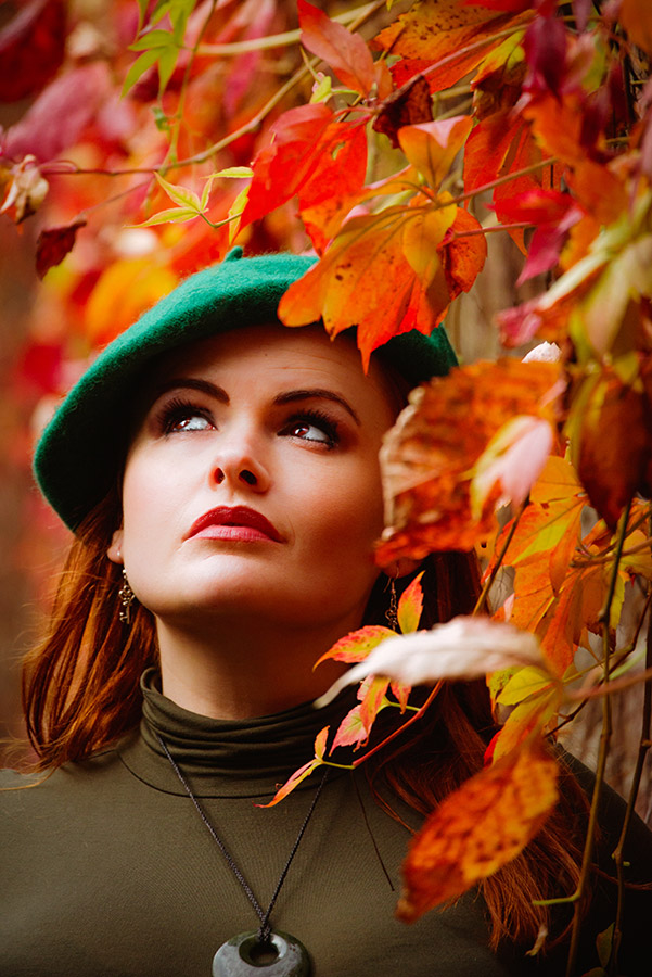 woman next to autumn leaves