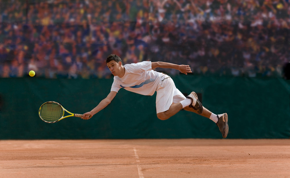Sports photography: Tennis player diving to hit ball on clay court, Credit: Photo and Co, Getty Images