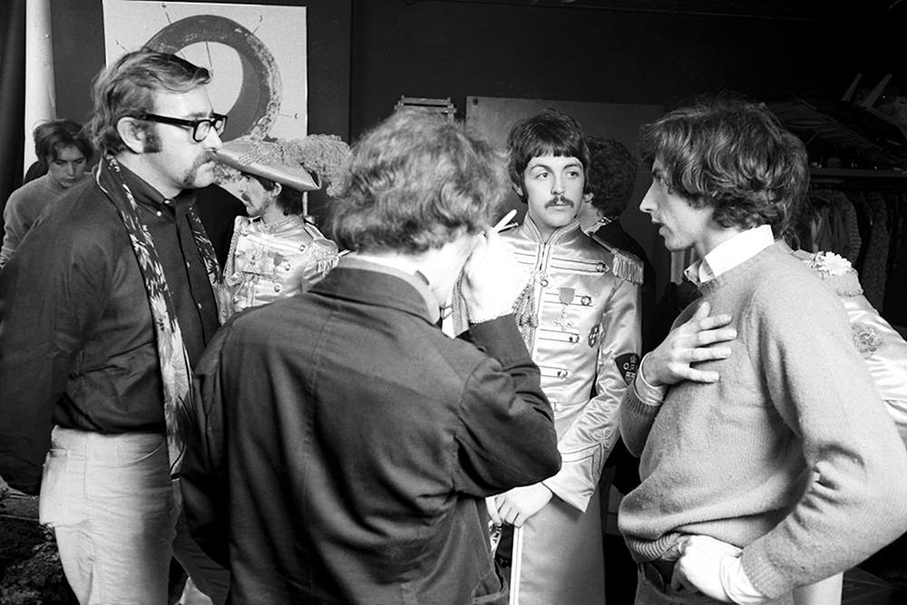 Preparing for the Sgt. Pepper’s Lonely Hearts Club Band shoot (foreground, from left to right, faces visible): Mal Evans, Paul McCartney and photographer Michael Cooper