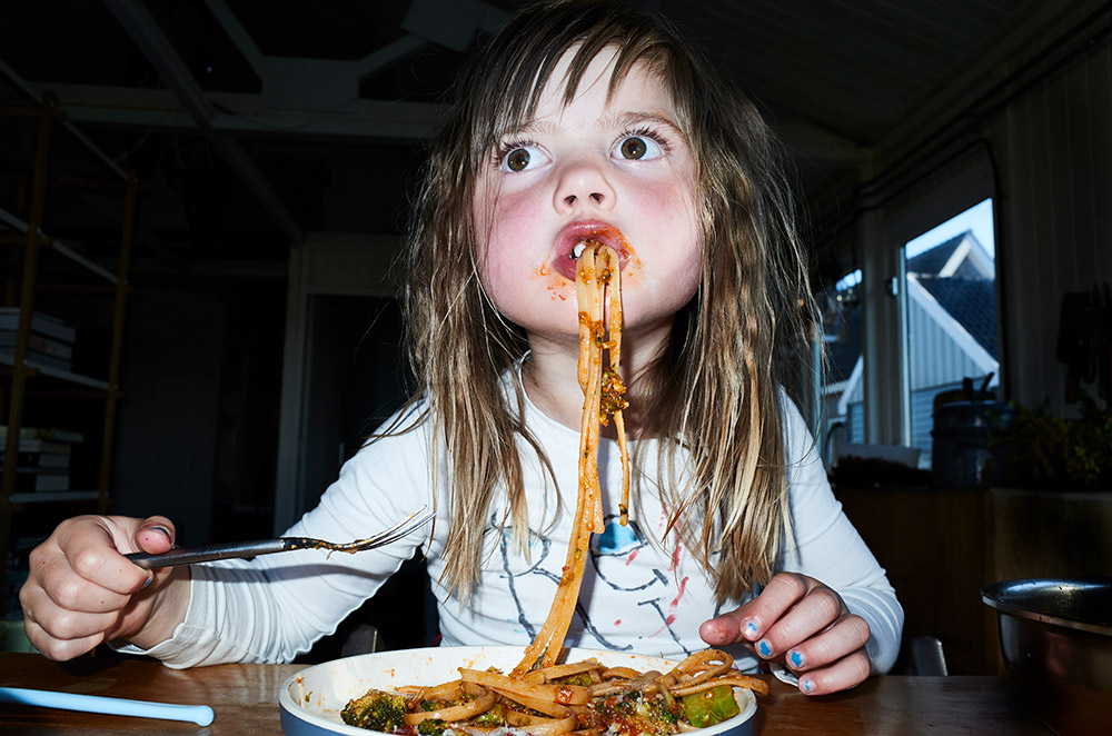 child eating pasta