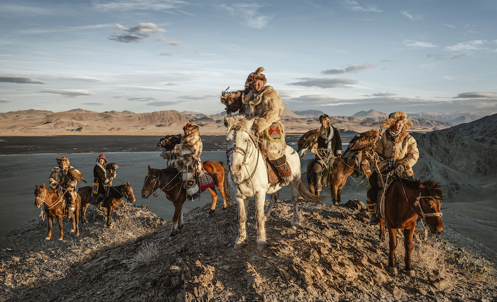 Reign of the Hunters. This is the family of 'Burgedchin' hunters of Mongolia. They have used their golden eagles to hunt for more than 250 years. The men are trained from the age of 10 in a harsh, extreme environment with their eagles on horseback. © Jatenipat Ketpradit/International Portrait Photographer of the Year 2022