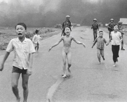South Vietnamese forces follow behind terrified children, including 9-year-old Kim Phuc, centre, as they run down Route 1 near Trang Bang after an aerial napalm attack on suspected Viet Cong hiding places. The Terror of War, aka Napalm Girl. © Nick Ut/AP/Shutterstock