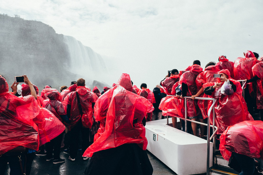 People Wearing Red Raincoat Against the famous Niagra Falls in Canada, Photo: Adam Vradenburg / EyeEm, Getty Images
