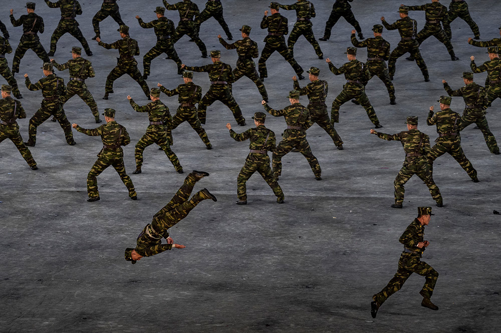 Men in military uniforms preform martial arts moves at the 2018 Mass Games entitled “The Glorious Country” at the Rungrado May Day Stadium, Pyongyang, North Korea. Image: Tariq Zaidi photography career