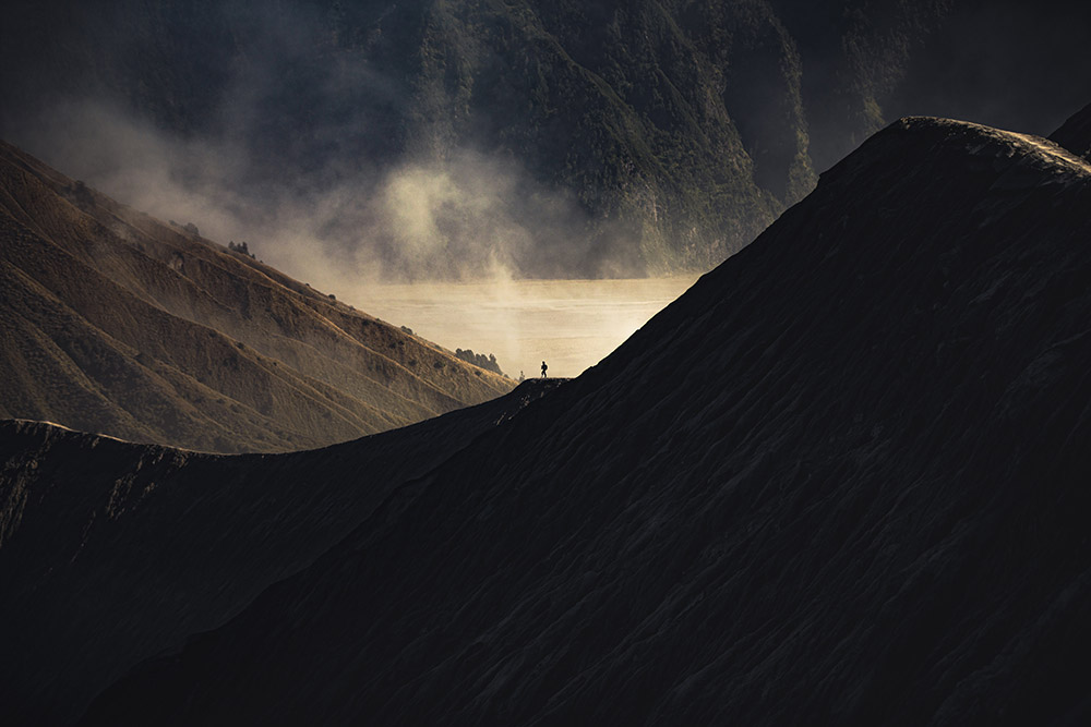 moody mountain landscape with person in the distance giving scale